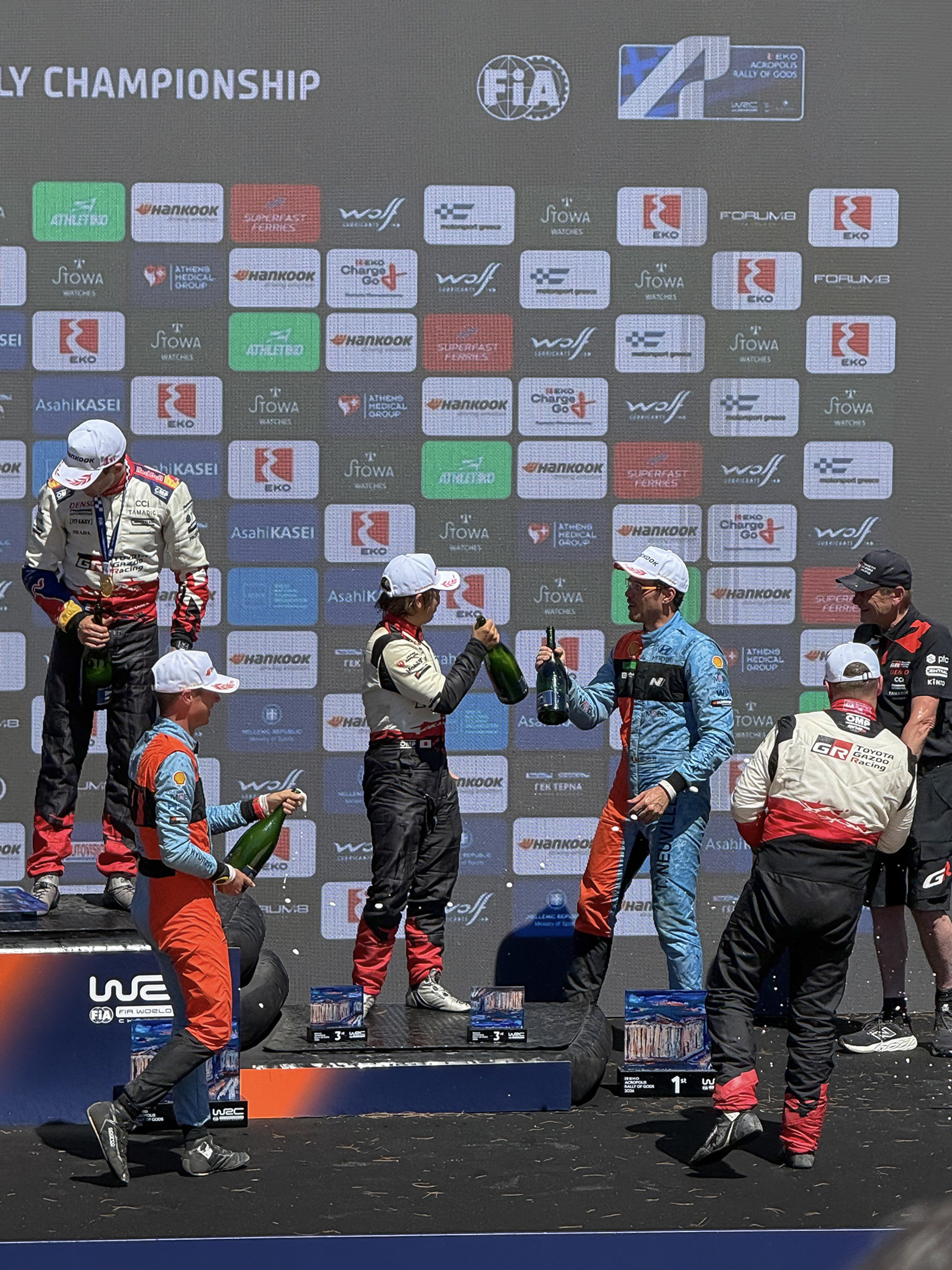WRC 시상대에서 선수들이 샴페인을 들고 축하하는 모습