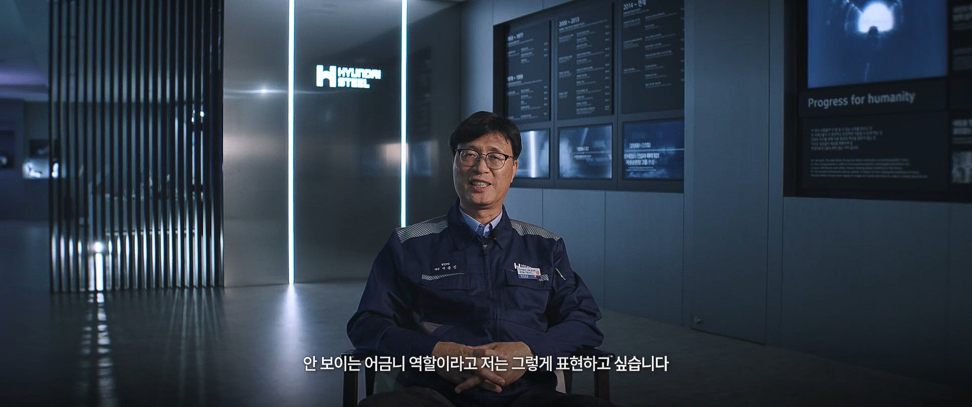 현대제철 전시 공간에서 현장 경험과 기술 계승에 대해 이야기하는 직원
